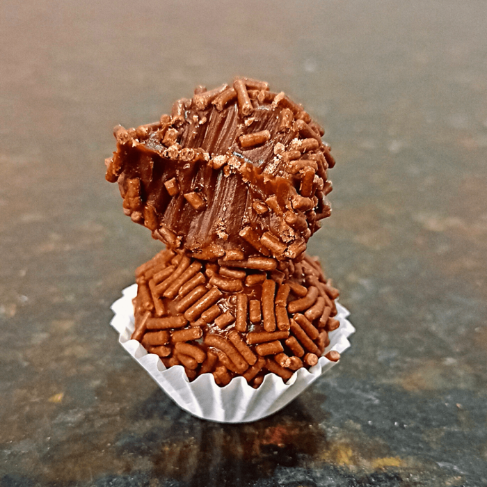 Brigadeiros de chocolate com granulado empilhados, prontos para venda